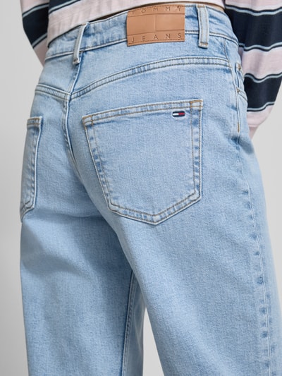 Männermodel trägt Straight Fit Jeans aus Baumwoll-Lyocell-Mix Modell 'SOPHIE' von Tommy Jeans w stylizowana na denim, naszywka z logo, szlufki na pasek, mieszanka bawełny i lyocellu, 5 kieszeni, jasny niebieski, Ganzkörperansicht Rückansicht.