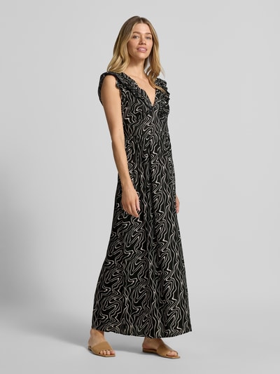 Frauenmodel trägt Leicht ausgestelltes Maxikleid aus reiner Viskose Modell 'EASY JOY' von Vero Moda mit Allover-Muster, ärmellos, tiefer V-Ausschnitt, Rüschen, Volantsaum, in Schwarz mit beigem Muster, Ganzkörperansicht von vorne.