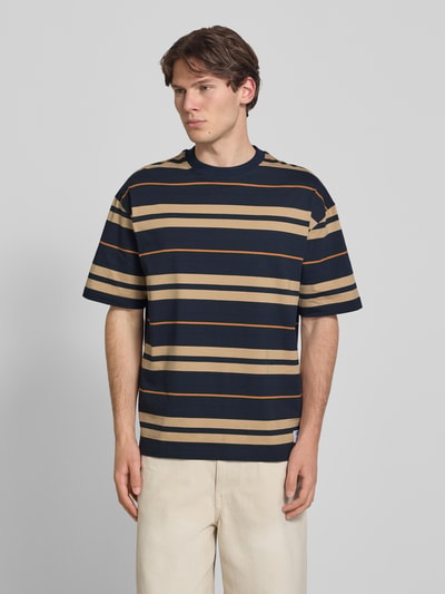 Mannenmodel draagt donkerblauw-beige gestreept oversized shirt uit pure katoen, model 'NIVARSI' van HUGO voor heren, frontale totaalopname.