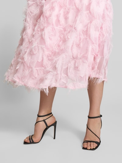 Kobiece model prezentuje różowe, teksturowane, frędzlowe Cocktailkleid mit Fransen Modell 'PAZYLLA' od YAS, długość midi, A-linia, z głębokim dekoltem V, długość tyłu w rozmiarze 36: 125 cm, szerokość w rozmiarze 36: 43 cm, długość rękawa w rozmiarze 36: 28 cm; detaliczne ujęcie dolnej części sukienki i nóg