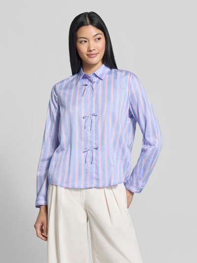 Frauenmodel trägt Regular Fit Hemdbluse aus reiner Baumwolle von Milano Italy, gestreiftes Muster in Blau und Rosa, Zierschleifen, Ganzkörperansicht von vorne.