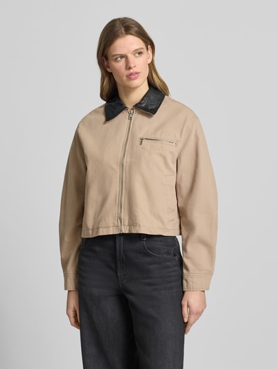 Frauenmodel trägt Jacke mit Brusttasche Modell 'SCOTTY' von Noisy May, Reine Baumwolle, Relaxed-Fit, Umlegekragen, Reißverschluss, Stitching, Beige und Schwarz, Ganzkörperansicht von vorne.