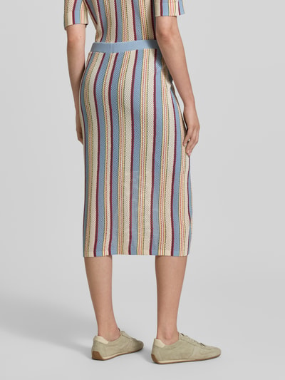 Vrouwenmodel draagt midirok in tricotlook van Jake*s Casual, nauwsluitende pasvorm, elastische band met tunnelkoord, bandwijdte maat 38: 42 cm, totale lengte maat 38: 76 cm, veelkleurige verticale strepen, fijngebreide textuur, ganzebovenaanzicht rugaanzicht.