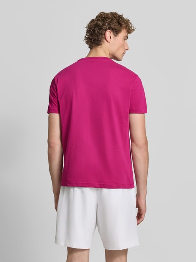 Männermodel trägt Regular Fit Sport-T-Shirt aus Baumwoll-Mix von Lacoste Sport in Pink, weiße Shorts, Ganzkörperansicht Rückansicht.