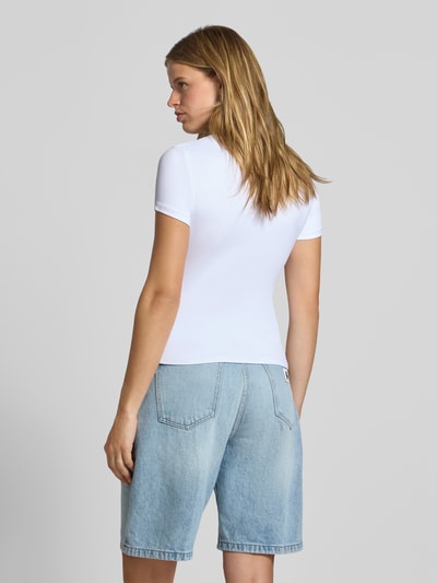 Vrouwenmodel draagt Slim Fit T-Shirt met ronde hals model 'LULA' van PIECES, dames t-shirt, wit, blauwe denim, geheellichaamsaanzicht achteraan.