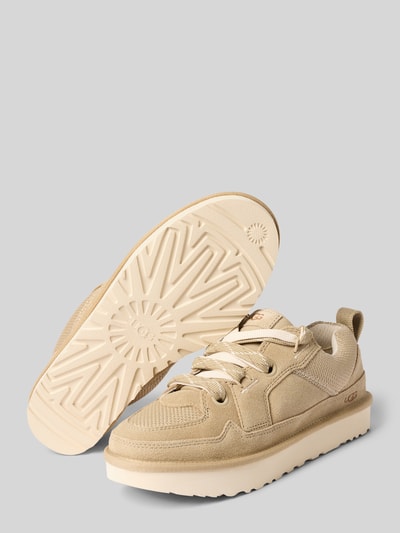 Produktfoto, Sneaker mit Plateausohle Modell 'LOWMEL' von UGG w beżowym kolorze, zaokrąglony kształt, sznurowanie, profilowana podeszwa, detale z logo, wysokość obcasa 3 cm, wysokość cholewki 7 cm, szerokość w rozmiarze 40: 9 cm, faktura zamszu i tkaniny