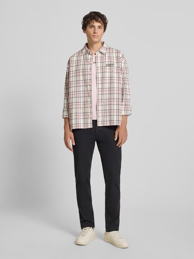 Męski model nosi Regular Fit Chino aus Baumwoll-Mix Modell 'CHINO II' od Levi's®, czarne spodnie, jasne tło, Ganzkörperansicht von vorne.