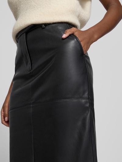 Vrouwenmodel draagt Midirok in leerlook van Calvin Klein Womenswear, los model, steekzakken, onderrok, detailopname heup.