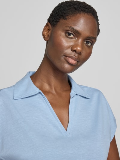 Frauenmodel trägt Regular Fit Poloshirt aus reiner Baumwolle von s.Oliver RED LABEL in hellem Blau, weiche Textur, Nahaufnahme Oberkörper.