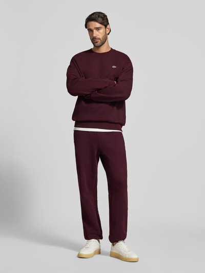 Männermodel trägt Classic Fit Sweatshirt aus Baumwoll-Mix von Lacoste in Dunkelrot, schlichtes Design, Herren Sweatshirt, Ganzkörperansicht von vorne