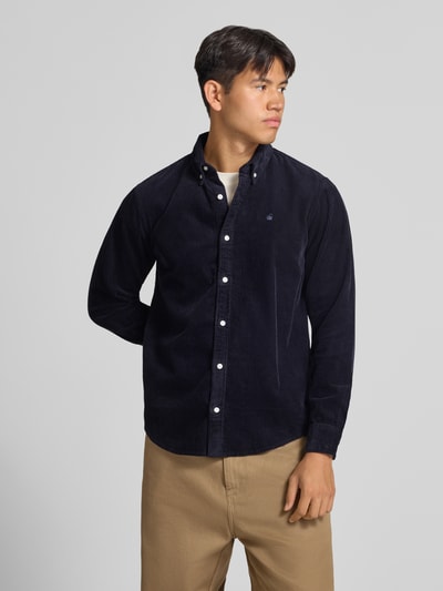 Männermodel trägt Regular Fit Freizeithemd mit Logo-Stitching Modell 'MADISON' von Carhartt Work In Progress, Nahaufnahme Oberkörper. Herren Freizeithemd aus reiner Baumwolle mit Button-Down-Kragen, Knopfleiste, Sportmanschetten und abgerundetem Saum.