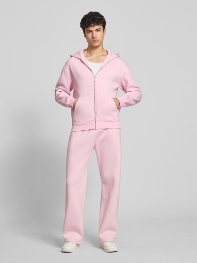 Männermodel trägt Sweatpants mit elastischem Bund von REVIEW in Rosa, Relaxed-Fit, Material-Mix mit Baumwoll-Anteil, Ganzkörperansicht von vorne.