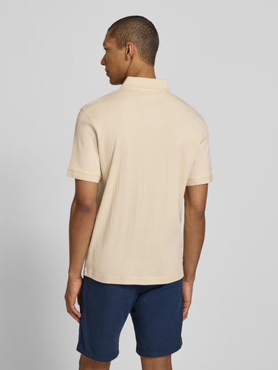 Männermodel trägt Regular Fit Poloshirt reiner Baumwolle Modell 'COLE' von SELECTED HOMME in Beige, Struktur-Jersey, Rückansicht Ganzkörperansicht.