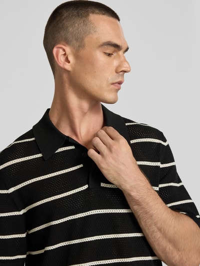 Männermodel trägt Poloshirt aus Viskose-Mix von Filippa K mit schwarzen und weißen Streifen, semitransparent, Nahaufnahme Oberkörper.
