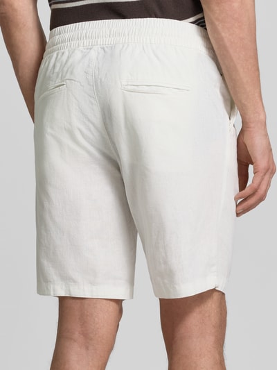 Männermodel trägt Shorts aus Leinen-Baumwoll-Mix Modell 'barton' von Matinique, weiß, Regular-Fit, elastischer Bund mit Tunnelzug, Ganzkörperansicht Rückansicht. Bundweite bei Größe M 43 cm, Innenbeinlänge 21 cm.