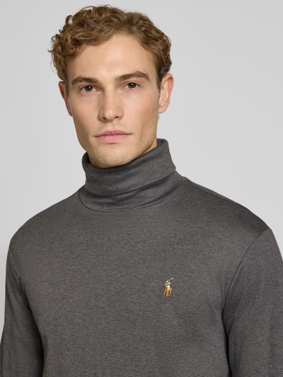 Männermodel trägt Regular Fit Rollkragenpullover aus reiner Baumwolle von Polo Ralph Lauren in Anthrazit, Nahaufnahme Oberkörper. Herren Rollkragenpullover von Polo Ralph Lauren.