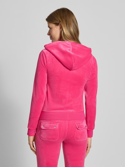 Frauenmodel trägt Sweatjacke mit Label-Stitching Modell 'ROBERTSON' von Juicy Couture in Pink, Material-Mix mit Stretch-Anteil, Ganzkörperansicht Rückansicht.