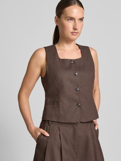 Vrouwenmodel draagt bodywarmer van mix van katoen en linnen model 'Yula' van Neo Noir, bruin, getailleerd model, vierkante hals, knoopsluiting, ruglengte maat 36: 49 cm, schouderbreedte maat 36: 30 cm, borstwijdte maat 36: 44 cm, vooraanzicht van bovenlichaam