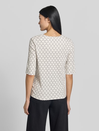 Kobiece model prezentuje Regular Fit T-Shirt mit Allover-Logo-Print von Marc Cain, mieszanka bawełny, okrągły dekolt, rękaw o dł. 1/2, długość tyłu w rozmiarze 36: 58 cm, widok całej sylwetki z tyłu