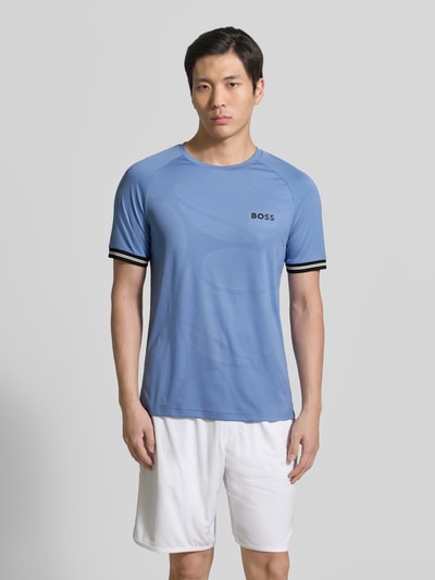 Männermodel trägt Regular Fit T-Shirt mit Label Print Modell 'TOC SERVE 2' von BOSS Green, unifarbenes Hellblau, Allover-Muster, Nahaufnahme Oberkörper.