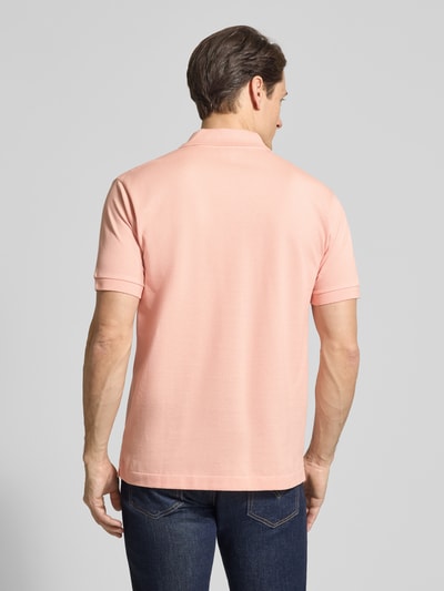 Männermodel trägt Regular Fit Poloshirt aus reiner Baumwolle von Lacoste, Optik: Unifarben, Piquéstruktur, Ganzkörperansicht Rückansicht.