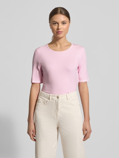Frauenmodel trägt Strickshirt aus Viskose-Mix mit Rundhalsausschnitt von Marc Cain, Damen, Regular-Fit, 1/2-Arm, Rückenlänge 51 cm, Ärmellänge 26 cm, zartrosa Farbton, schlichte Textur, sanfte Oberfläche, Ganzkörperansicht von vorne.