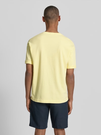 Männermodel trägt T-Shirt mit Ärmelaufschlag und Rundhalsausschnitt von Drykorn, Reine Baumwolle, Regular-Fit, Rückenlänge 70 cm, Ganzkörperansicht Rückansicht.