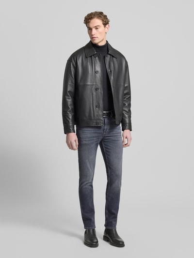 Männermodel trägt Slim Fit Jeans aus Baumwoll-Mix Modell 'DELAWARE' von BOSS in Denim-Optik, Ganzkörperansicht von vorne. 5-Pocket-Design, Label-Patch, Metall-Applikation und Nieten betonen den Slim-Fit, Knopf und verdeckter Reißverschluss ergänzen, Baumwoll-Mix sorgt für angenehme Textur.