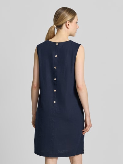 Männermodel trägt knielanges Kleid aus Leinen-Viskose-Mix Modell 'LAVA' von FREE/QUENT, granatowy kolor, prosty krój, runda szyja, długość midi, długość pleców w rozmiarze S: 95 cm, szerokość w rozmiarze S: 50 cm, tekstura gładka, widok całej sylwetki od tyłu