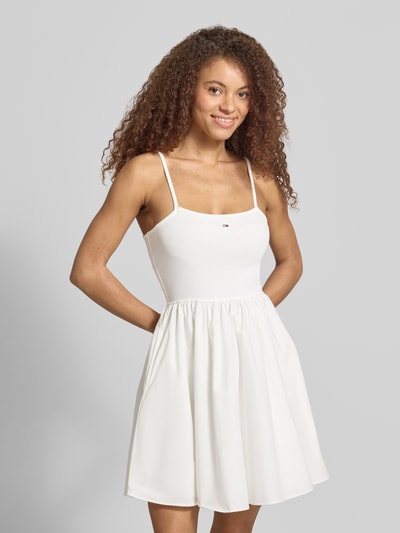 Frauenmodel trägt Tailliertes Freizeitkleid aus reiner Baumwolle von Tommy Jeans in Optik: Unifarben, Mini-Länge, U-Ausschnitt, Logo-Stitching, Spaghettiträger, gerader Saum, seitliche Eingrifftaschen, Material: Reine Baumwolle, Ganzkörperansicht von vorne.