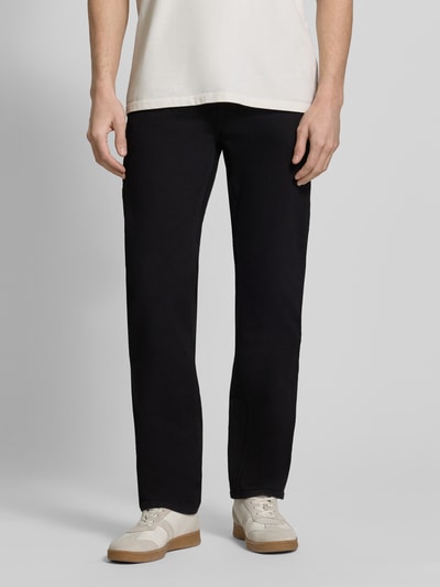 Männermodel trägt Slim Fit Jeans im 5-Pocket-Design Modell 'ANGELS' von Guess in Schwarz, aus Baumwoll-Elasthan-Mix, Ganzkörperansicht von vorne.