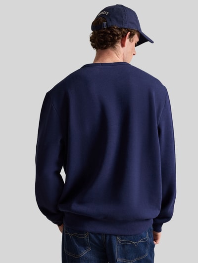 Männermodel trägt Regular Fit Sweatshirt aus Baumwoll-Mix von Polo Ralph Lauren in Dunkelblau, glatte Struktur, Ganzkörperansicht Rückansicht. Herren Sweatshirt von Polo Ralph Lauren.