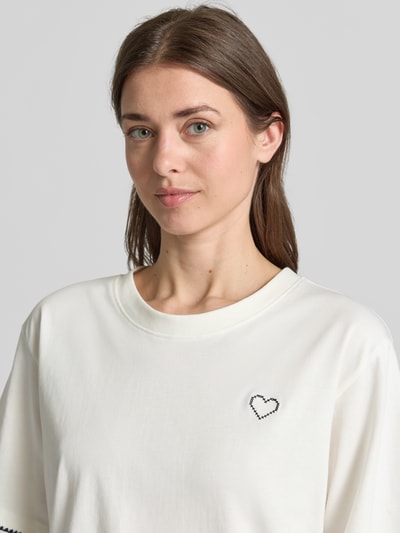 Frauenmodel trägt T-Shirt mit Rundhalsausschnitt und Stitchings von FREE/QUENT in Weiß, reine Baumwolle, relaxed Fit, Nahaufnahme Oberkörper.