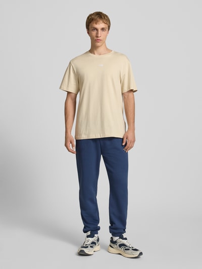 Mannenmodel draagt T-Shirt met Logo-Stitching van The North Face in beige, katoen, rechte fit, geribde ronde hals, vooraanzicht hele lichaam