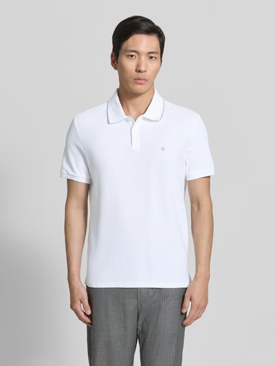 Männermodel trägt Poloshirt mit Logo Stitching aus reiner Baumwolle von CK Calvin Klein, Optik: Unifarben, Regular-Fit, Polokragen, Kurzarm, Ganzkörperansicht von vorne.