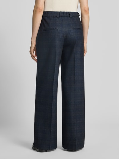 Männermodel trägt Wide Fit Hose mit Viskose-Anteil von Oui, mieszanka wiskozy, krój wide fit, ozdobne szwy, kieszenie z tyłu, zapięcie na haftkę i zamek błyskawiczny, Szerokość w rozmiarze 36: 39 cm, Długość wewnętrzna nogawki w rozmiarze 36: 80 cm, widok całej sylwetki z tyłu.