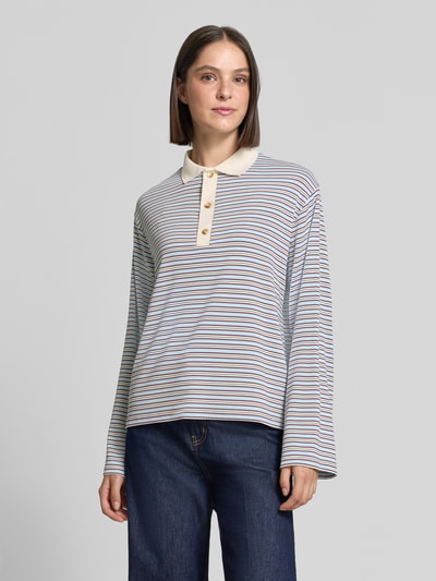 Frauenmodel trägt Relaxed Fit Poloshirt in langärmeligem Design von Neo Noir, gestreiftes Muster, elastischer Mix, Ganzkörperansicht von vorne. Rückenlänge bei Größe 36: 62 cm.