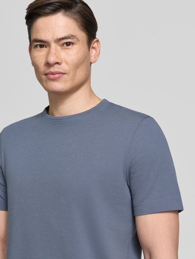 Männermodel trägt Regular Fit T-Shirt aus Baumwoll-Mix Modell 'TIBURT 240' von BOSS, Optik: Unifarben, Kurzarm, Nahaufnahme Oberkörper.