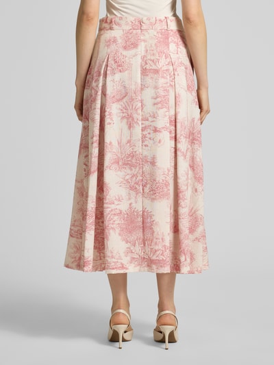 Vrouwenmodel draagt midirok in all-over look met roze plooien, model 'PALMIRA' van SEDUCTIVE, A-lijn, detailopname achterkant. Context: dames midirok van SEDUCTIVE, a-lijn, all-over look, model 'PALMIRA', plooien, bandwijdte maat 36: 39 cm, totale lengte maat 36: 88 cm.