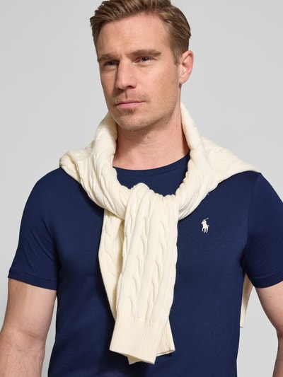 Męski model nosi Regular Fit T-Shirt aus reiner Baumwolle von Polo Ralph Lauren, efekt: jednolity kolor, krój regular fit, wyhaftowane logo, okrągły dekolt, krótki rękaw, wykończenie: dżersej, materiał: bawełna, kolor granatowy, z przodu zbliżenie na górną część ciała.