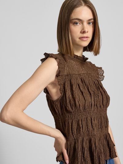 Frauenmodel trägt Only Slim Fit Blusentop mit Rüschenkragen Modell 'SHAILA' in Braun, Optik: Unifarben, Häkel-Details, Raffung, Nahaufnahme Oberkörper.