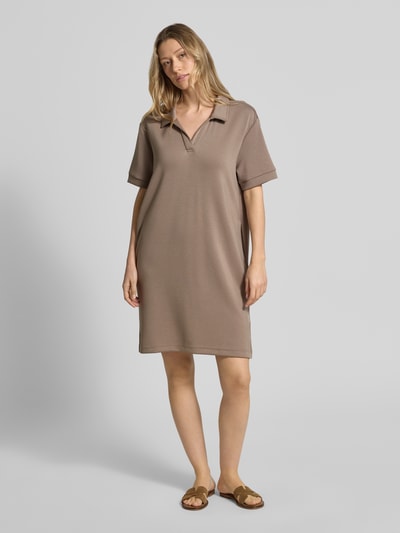 Kobieta modelka nosi Regular Fit Polokleid mit Modal-Anteil von Marc O'Polo, efekt: jednolity kolor, krój regular fit, długość mini, dekolt w serek, krótki rękaw, boczne rozcięcia, mieszanka materiałów z modalu, całe ciało z przodu.