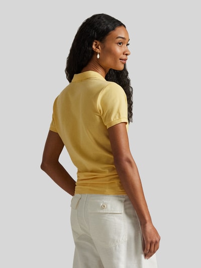 Modelka prezentuje Slim Fit Poloshirt aus Baumwoll-Mix von Polo Ralph Lauren, efekt: jednolity kolor, krój slim fit, wyhaftowane logo, kołnierzyk polo, zapięcie: krótka listwa guzikowa, rękaw: krótki rękaw, wykończenie: z rozcięciem, wykończenie materiału: pika, mieszanka bawełny, całkowity widok z tyłu.