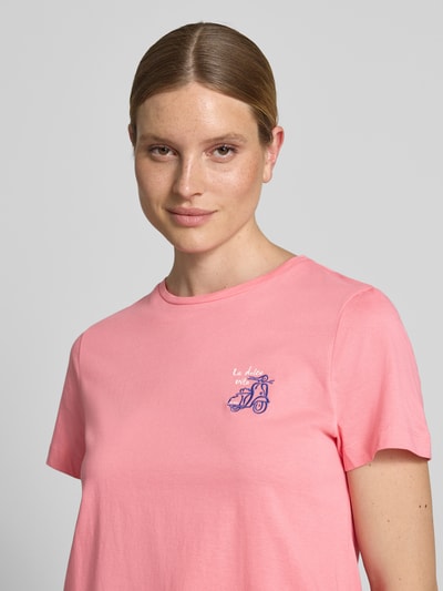 Frauenmodel trägt Regular Fit T-Shirt aus reiner Baumwolle von Tom Tailor in Unifarbe Rosa mit Motiv-Print, Nahaufnahme Oberkörper.