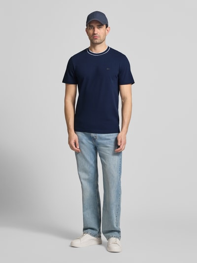 Männermodel trägt Regular Fit T-Shirt aus Baumwoll-Mix von Lacoste, Optik: Unifarben, Kurzarm, Logo-Stitching, Piqué, Ganzkörperansicht von vorne.
