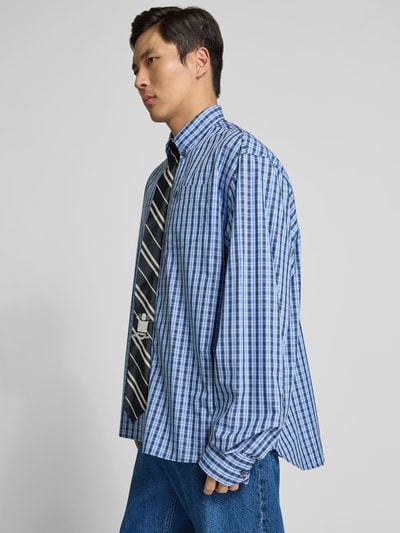Männermodel trägt Relaxed Fit Freizeithemd aus Reine Baumwolle von VETEMENTS mit Durchgehende Knopfleiste, integrierte Krawatte, Langärmlig, kariertes Muster in Blau, Rückenlänge 84 cm, Schulterbreite 58 cm, Ärmellänge 72 cm, Ganzkörperansicht von vorne.