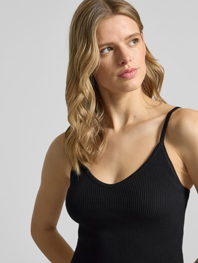 Frauenmodel trägt Crop Top aus Viskose-Mix Modell 'ESTHER' von JJXX, Damen Trägertop in Schwarz, V-Ausschnitt, Spaghettiträger, Nahaufnahme Oberkörper.