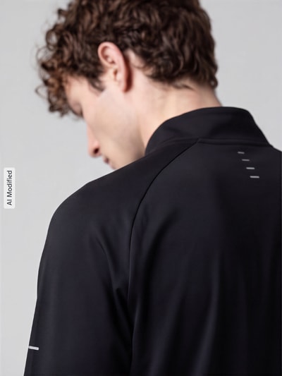 Männermodel trägt Regular Fit Sport-Langarmshirt mit Troyer-Kragen von Nike Training, schwarzer Stoff, glatte Textur, Ganzkörperansicht Rückansicht, KI-modifiziertes Bild.