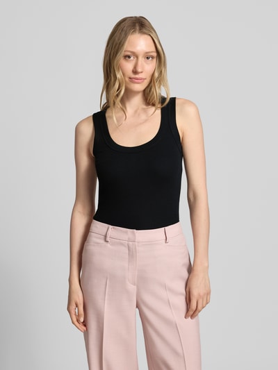 Frauenmodel trägt Tanktop mit Rundhalsausschnitt von Marc Cain in Schwarz, körpernaher Schnitt, Feinrippstruktur, Nahaufnahme Oberkörper.