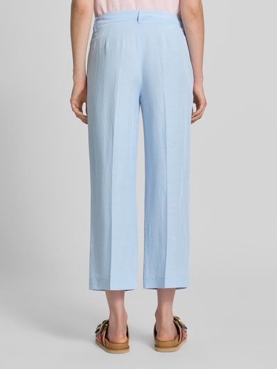Frauenmodel trägt Stoffhose mit Bügelfalten Modell 'OLESSA' von Raffaello Rossi, hellblau, glatte Textur, 7/8 Fit, Ganzkörperansicht Rückansicht. Viskose-Mix mit Leinen-Anteil, Haken- und Reißverschluss, französische Eingrifftaschen.